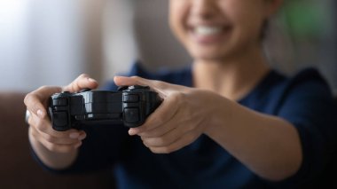Close up happy young Indian woman using remote controller.