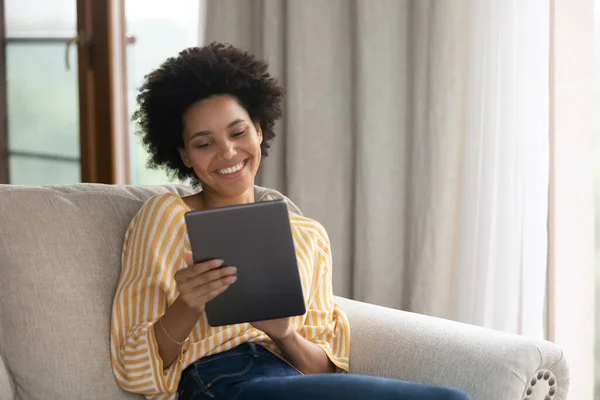 Relajada sonriente joven afroamericana mujer usando tableta. — Foto de Stock