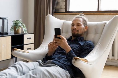 Happy handsome young hipster man using cellphone apps.