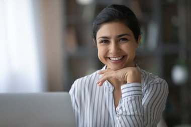 Portrait of pretty Indian businesswoman sitting at table.