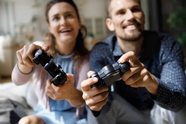 Happy laughing young family couple playing video games at home. — Stockfoto