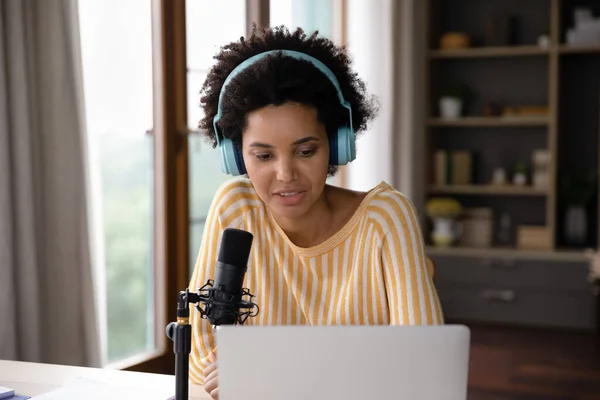 Focused pretty young African American businesswoman recording audio podcast. — Stock Photo, Image