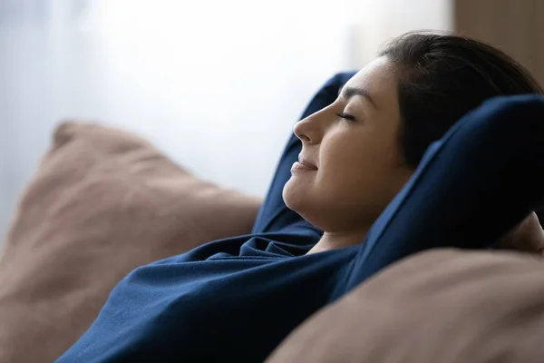 Peaceful happy young Indian woman resting on cozy sofa. — Fotografia de Stock