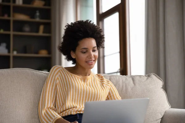 Smiling young African American woman using computer. — Stock fotografie