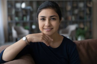 Happy beautiful relaxed young Indian woman looking at camera.