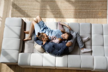 Relaxed smiling bonding young family couple communicating at home.