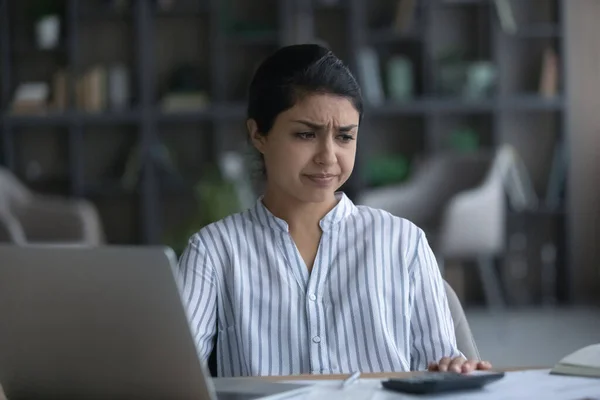 Unhappy young Indian woman feeling stressed calculating expenditures. — Stok Foto