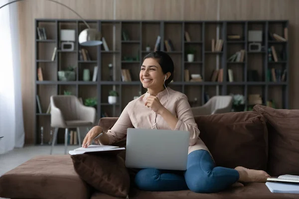 Happy young dreamy Indian woman studying online. — Stockfoto