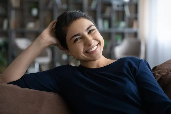 Portrait happy beautiful young Indian woman resting on sofa. — Stockfoto