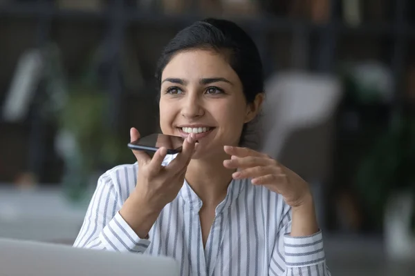 Happy young Indian woman recording audio message on cellphone. — Stock fotografie