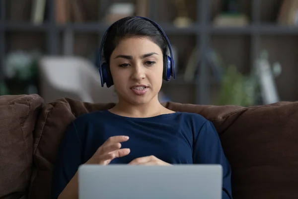 Mujer india milenaria concentrada que celebra una reunión de video llamada. — Foto de Stock