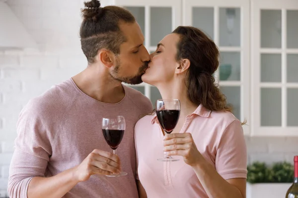 Affectionate loving young family couple kissing, clinking glasses. — Stok fotoğraf