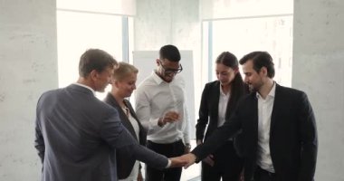 Businesspeople celebrate success, make hand gesture of teamwork and unity