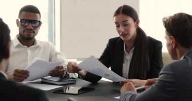 Diverse group of company employees gather in boardroom for briefing