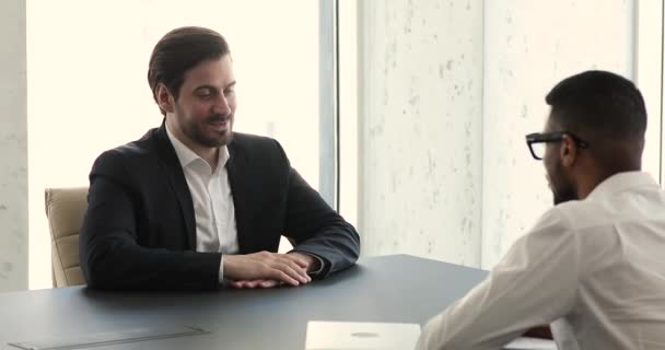 Applicant answers questions during job interview in company boardroom — Vídeos de Stock