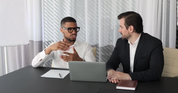 Multiracial colleagues discuss business sit at table in modern office — Stok video