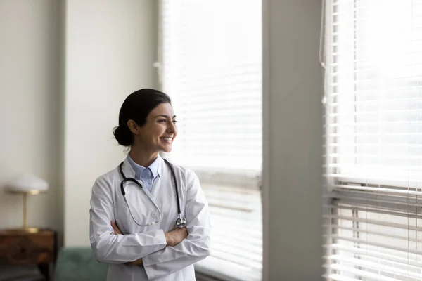 Confident happy young Indian doctor thinking in clinic office. — Stock Photo, Image