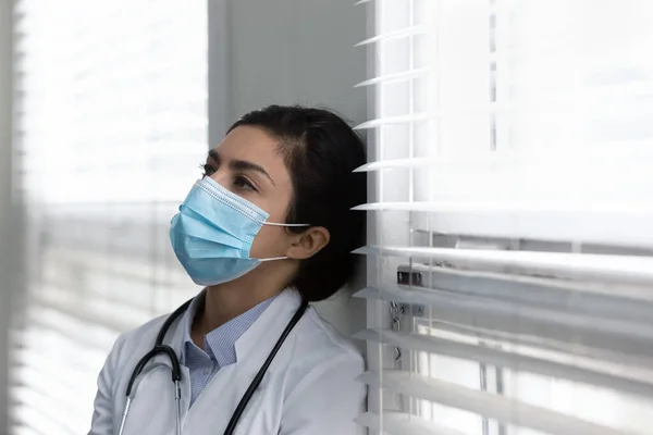 Unhappy young Indian doctor feeling exhausted in clinic. — Photo