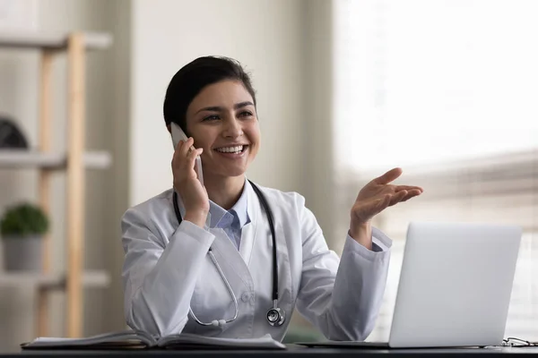 Happy young Indian doctor holding cellphone conversation. — Stok fotoğraf