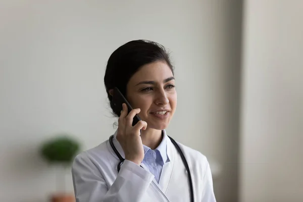 Happy young Indian doctor holding cellphone conversation. — Stockfoto
