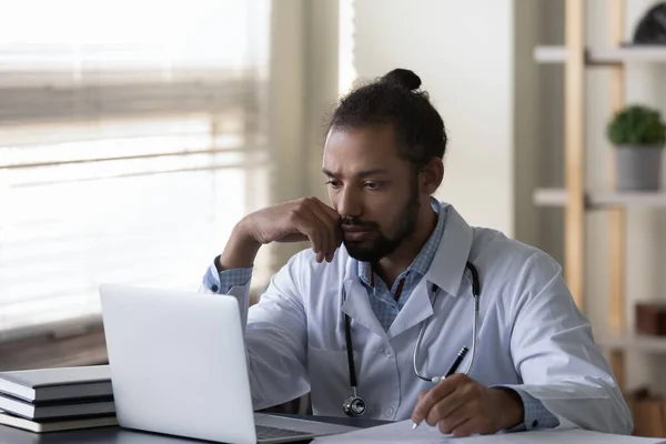 El estresado joven médico afroamericano pensando en la solución del problema. —  Fotos de Stock