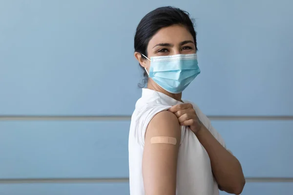 Portrait of happy young Indian woman showing place after vaccination. — Stock Photo, Image