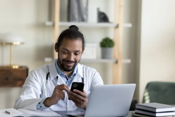 携帯電話を使ってアフリカ系アメリカ人の若い医者を微笑む. — ストック写真