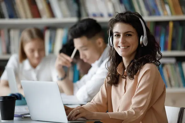 Chica estudiante feliz en los auriculares que trabajan en el proyecto de investigación — Foto de Stock