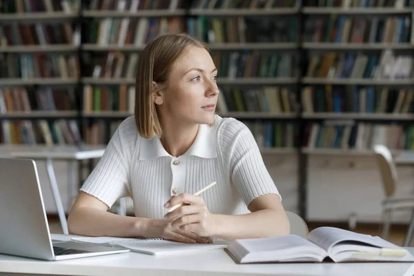 Thoughtful dreamy pretty student girl working on essay — Stock Photo, Image