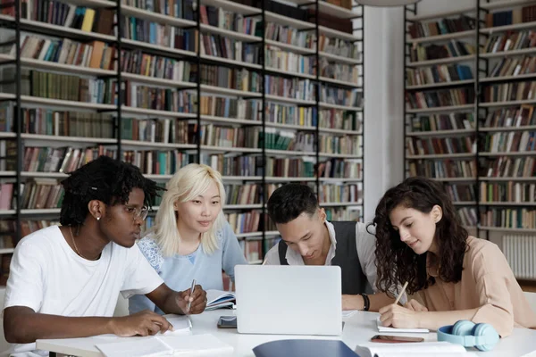 Multi-etnische groep universiteitsstudenten die samenwerken op laptop — Stockfoto