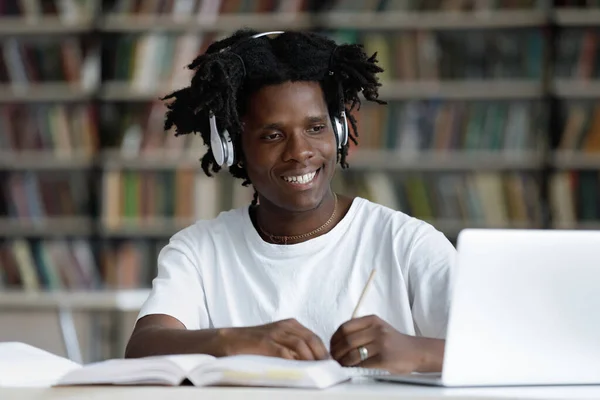 Felice africano studente ragazzo in cuffie guardando apprendimento webinar — Foto Stock