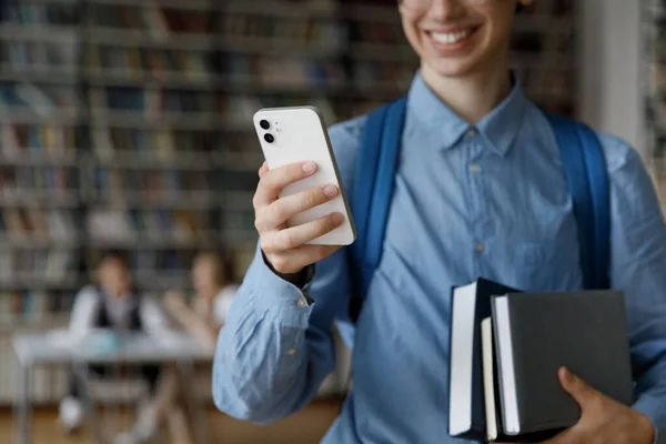Счастливый студент с помощью онлайн-приложения, интернет-сервиса на смартфоне — стоковое фото
