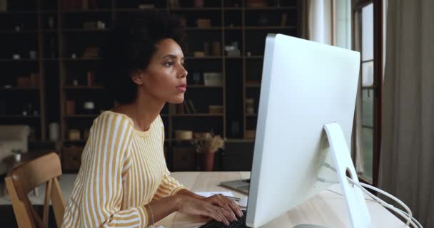 Seriöse afrikanische Geschäftsfrau sitzt am Schreibtisch und arbeitet am Computer — Stockvideo