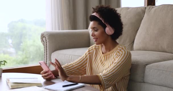 Mulher africana detém celular cantar música ouvir música através de fones de ouvido — Vídeo de Stock