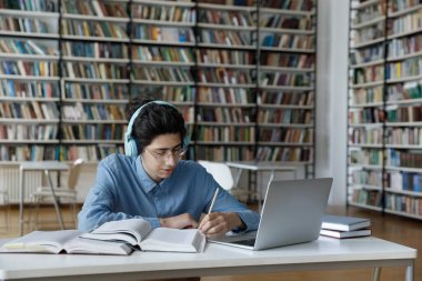 Gözlüklü ve kulaklıklı zeki inek öğrenci çok çalışıyor.