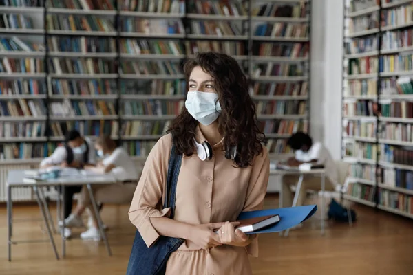 Estudiante hispana sonriente con máscara de protección médica visitando al público — Foto de Stock