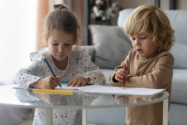 Feliz adorable niños pequeños dibujo de imágenes en el álbum de papel. — Foto de Stock