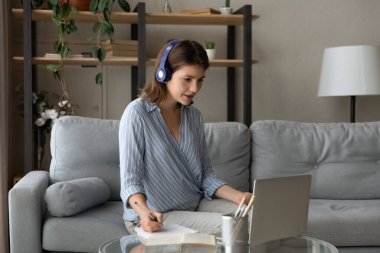 Çevrimiçi kurslarda okuyan konsantre olmuş güzel bir genç kadın..