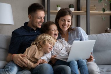 Modern teknolojiye bağımlı mutlu aile bilgisayarı kullanıyor..