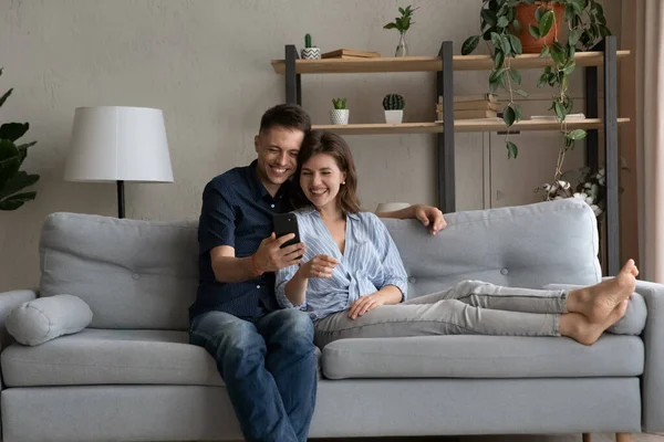 Feliz unión joven familia pareja usando teléfono inteligente. — Foto de Stock