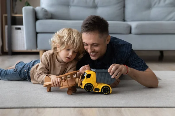 Sorridente bambino piccolo ragazzo giocare giocattoli con papà affettuoso. — Foto Stock