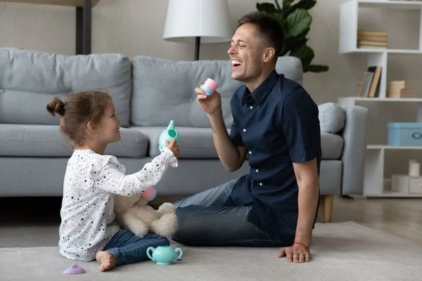 Söt liten flicka som leker med skrattande far. — Stockfoto