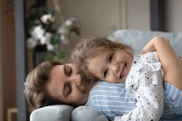 Affectueux sourire millénaire mère câlins mignon petite fille. — Photo