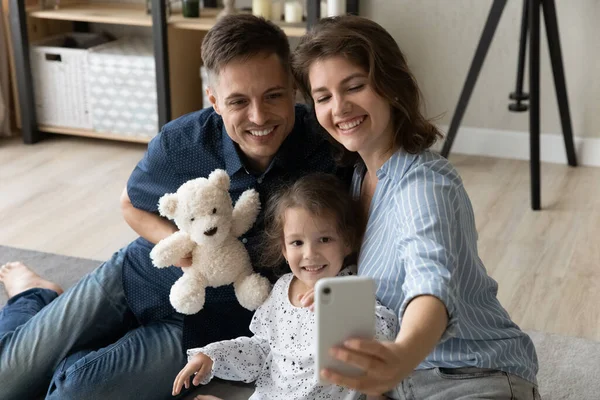 Sourire jeune mère posant pour selfie avec mari et fille. — Photo