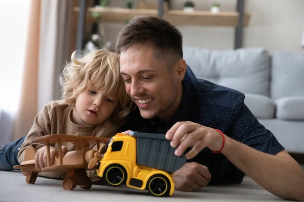 Gioioso adorabile bambino che gioca giocattoli con padre premuroso. — Foto Stock