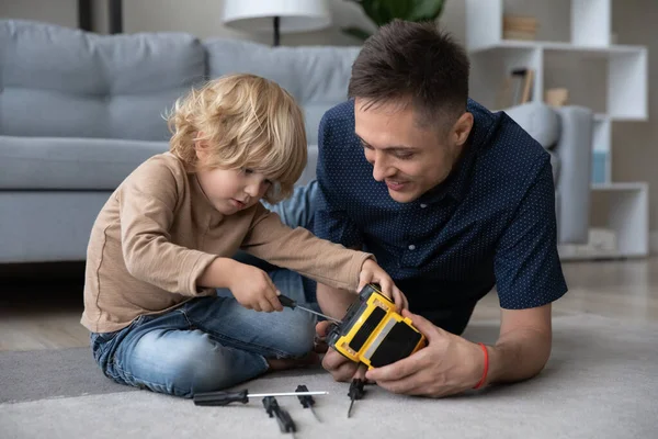 Divertido adorable niño pequeño juguete de fijación con padre cariñoso. —  Fotos de Stock