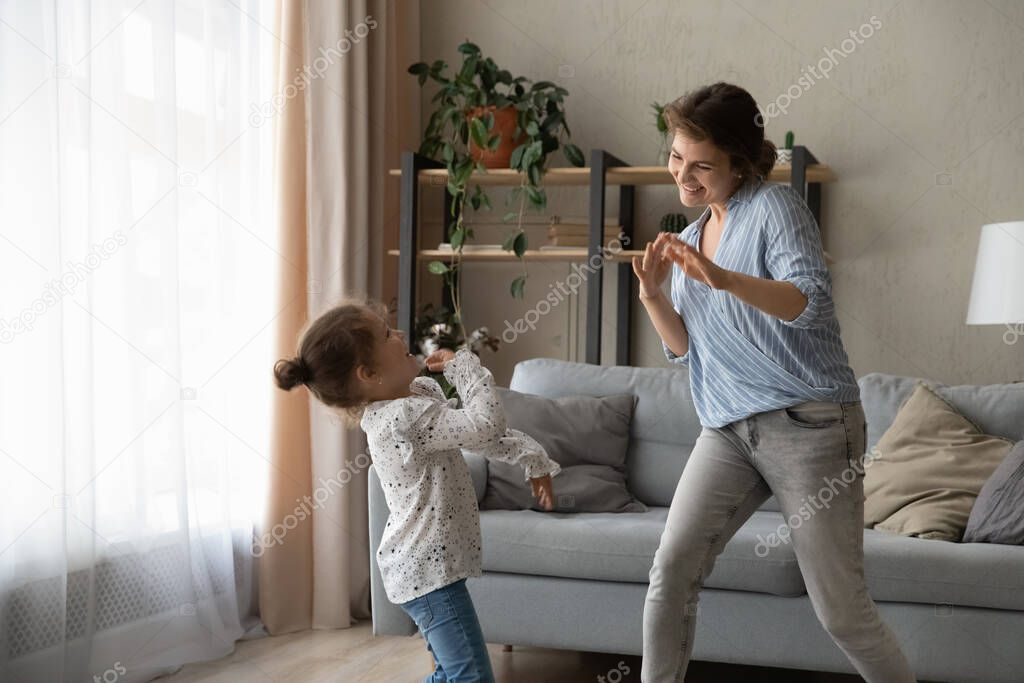 Overjoyed small kid girl dancing with mum.