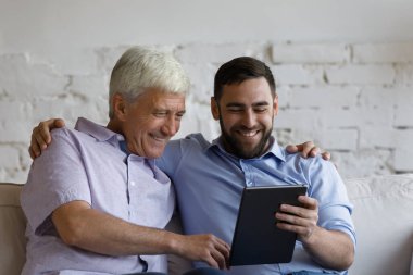 Mutlu yetişkin oğul olgun babaya online uygulama kullanmayı öğretiyor.