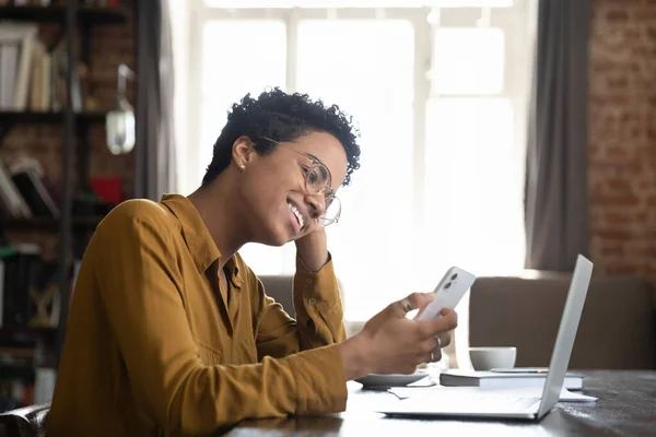 Happy African millennial gadget user girl making video call