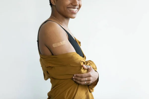 Feliz dama afroamericana mostrando hombro con yeso adhesivo —  Fotos de Stock